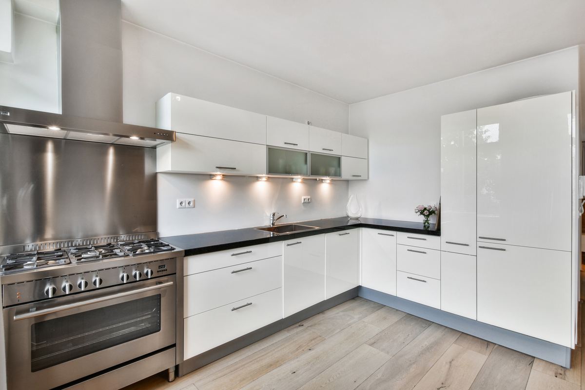 Empty, clean white kitchen with cabinets and stainless appliances in a new home